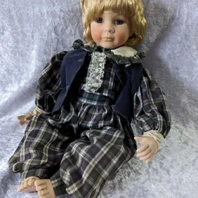 Porcelain sitting doll in velvet waistcoat