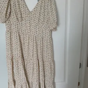 summer daisy dress, on a beige background,  zip back and cut out detail. flattering side split