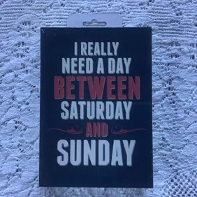 Amusing display hanging/stand. “I really need a day between Saturday and Sunday”. Unused, cellophane