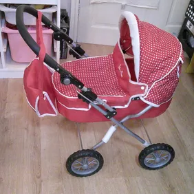 Red Silver Cross dolls pram with cover and dolls change bag. Pram has adjustable handle and folds fl